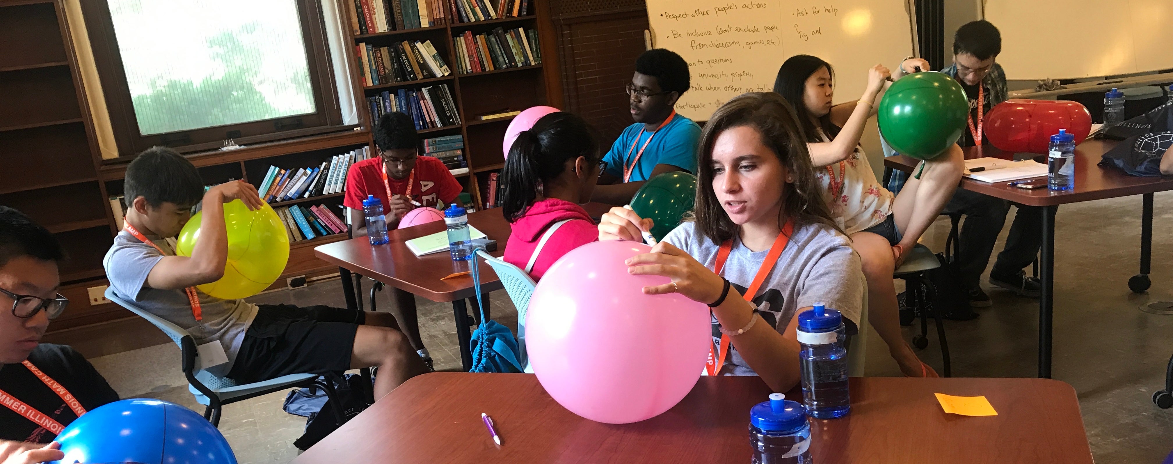 Campers drawing on balloons 