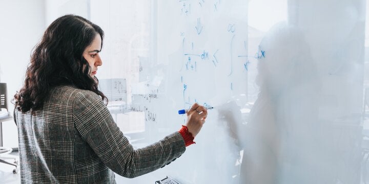 student writing on a whiteboard