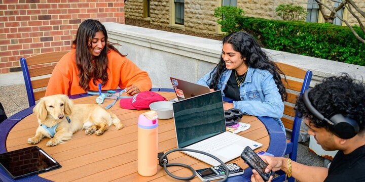 Students sitting at table eating.