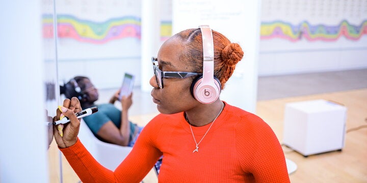 Student writing on whiteboard.