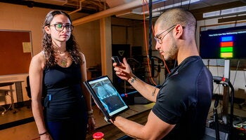 Graduate student Jonathan Cerna monitors heart data from a “smart shirt” that tracks electrical activity as graduate student Laila Shaaban exercises and rests. 