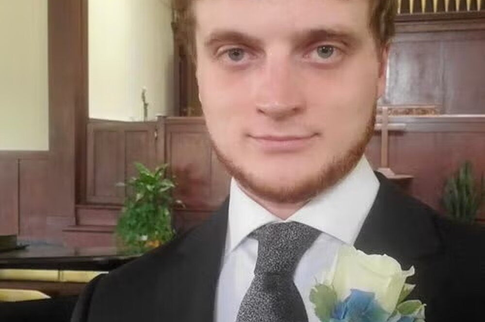 Professor Ben Castle in suit and tie with a corsage.
