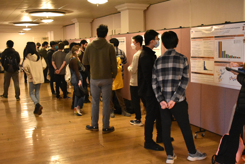 photo of students and faculty observing poster presentations during IGL open house event