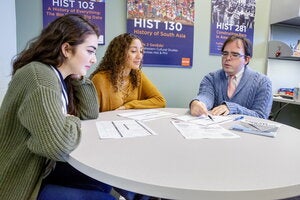 Advisor sitting with students.
