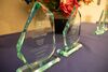 Glass awards sit atop a decorated table. The one furthest left reads "Emily Lange 2023–2024 LAS Staff Award."