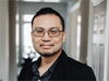 Portrait of Alexander Yong wearing gray button-up and black jacket